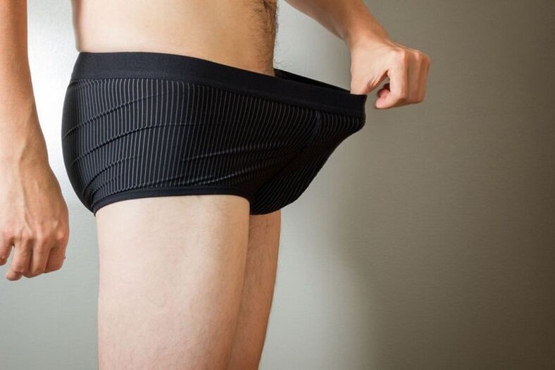 Ein Mann blickt in seine Hose und möchte seinen Penis mit Limonade vergrößern